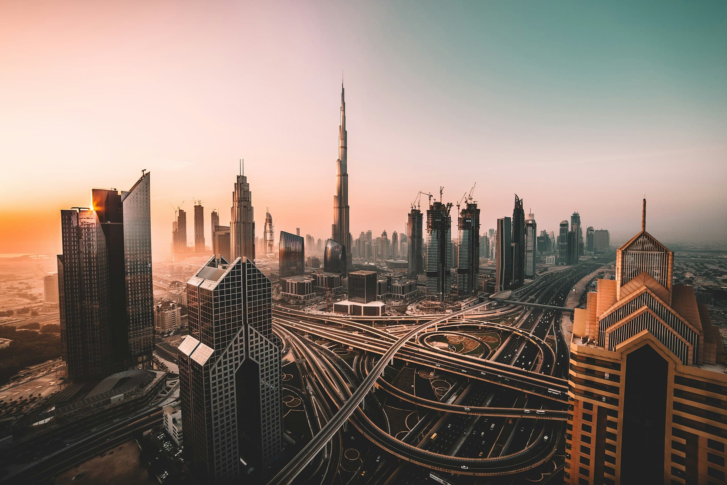 Dubai skyline at sunset with Burj Khalifa and highway interchange, Middle East technology hub